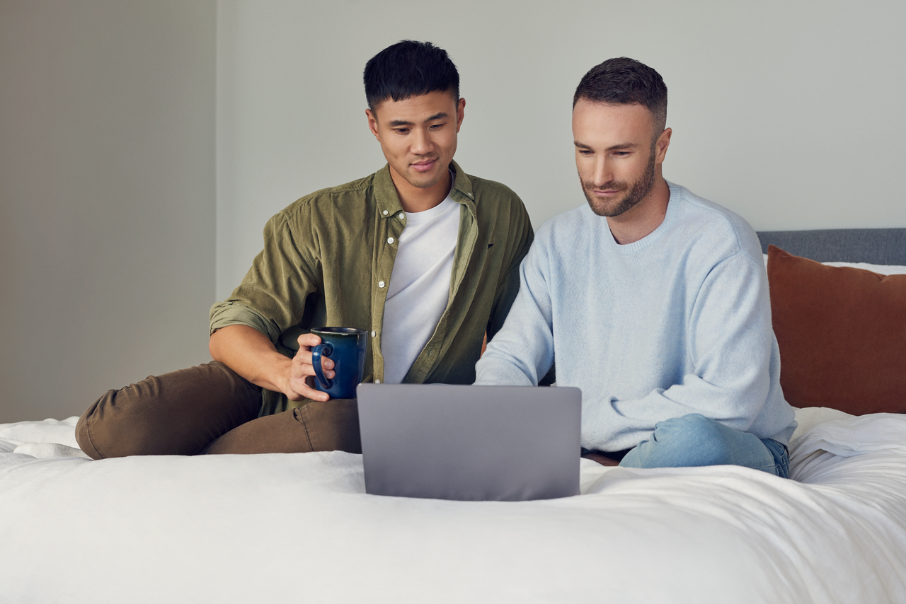 Men sitting on bed with lap top 1